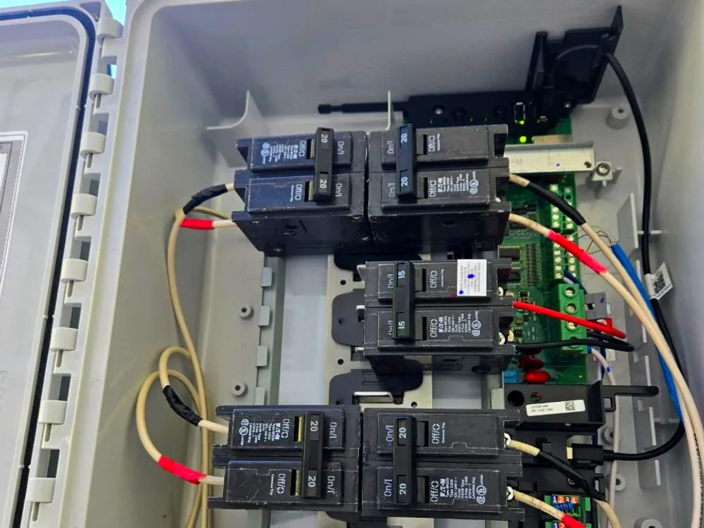 A combiner enclosure rewired with new breakers, colour-coded conductors and a tidy grounding bar
