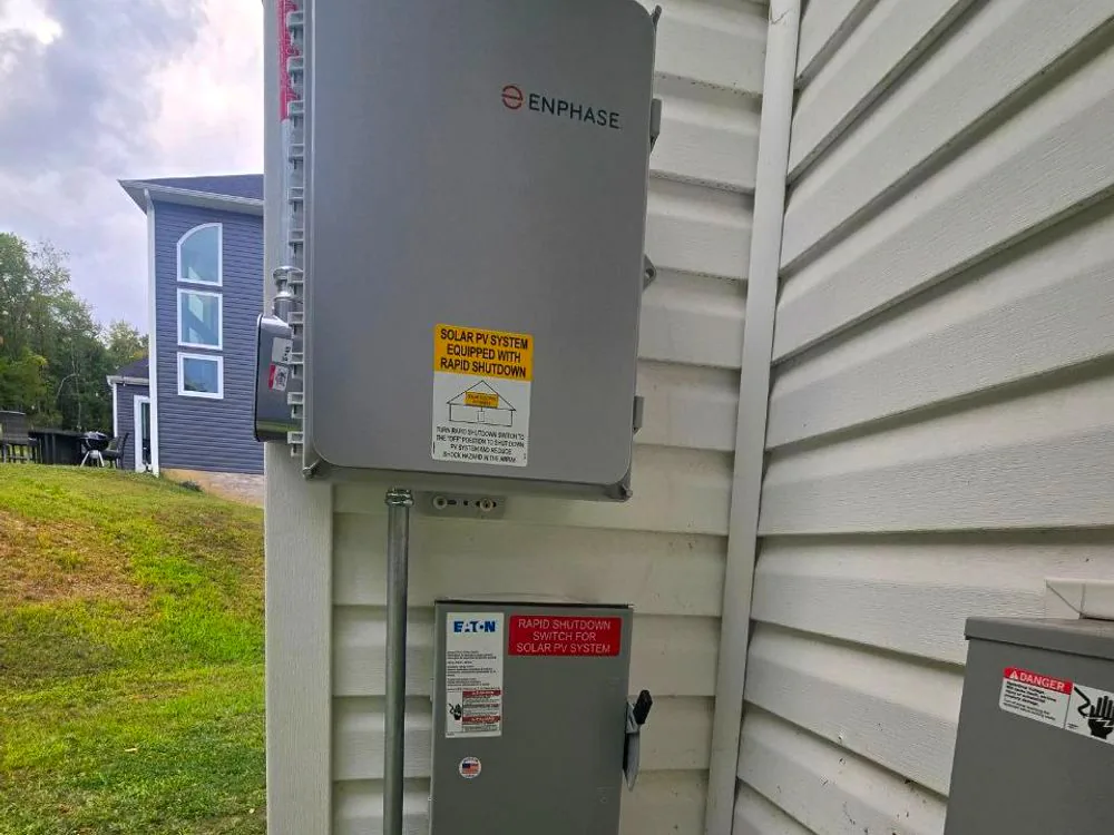 Combiner and AC disconnect mounted together on an exterior wall after commissioning